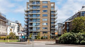 A multi-story residential building with balconies, a brick facade, and a modern design. - Chic Urban Seaside Apartment (Nieuwpoort)
