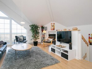 A modern living room with a sofa, a coffee table, a TV, and a bookshelf. - 8 Person Holiday Park Home in Bogense (Bogense)
