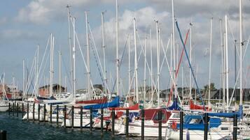 A marina with multiple boats docked at wooden piers.
