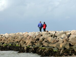 Two people walking on a rocky shoreline. - 8 Person Holiday Park Home in Bogense (Bogense)