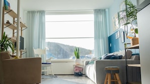 Un salon moderne avec un canapé, un fauteuil et un coin repas.