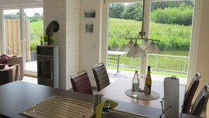 A modern kitchen with a large window, a dining area, and a small outdoor table.
