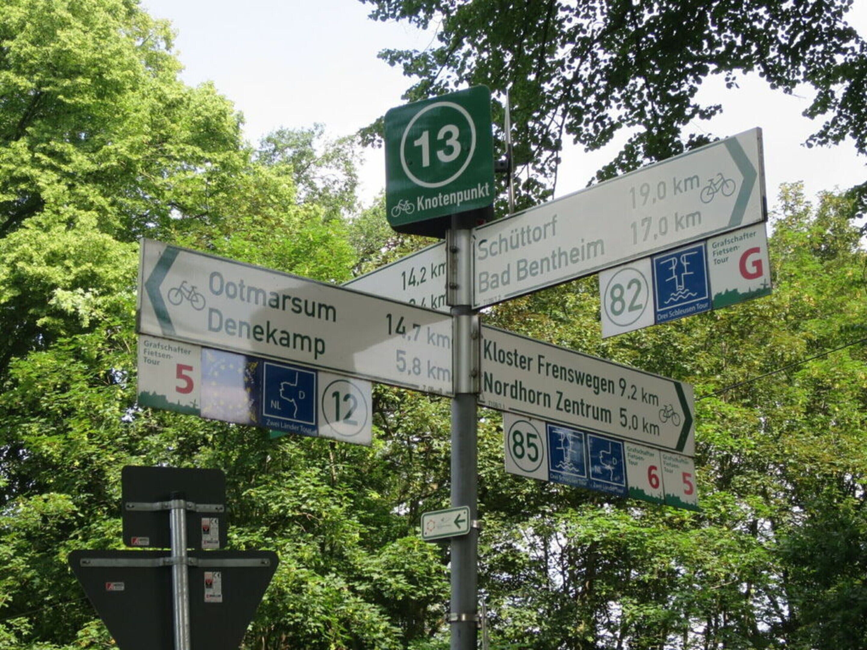 A directional signpost with multiple route options and distances.