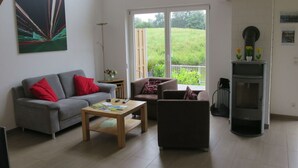 A spacious living room with a grey sofa, a wooden coffee table, and a fireplace.
