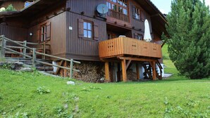 A multi-story wooden chalet with a balcony, a satellite dish, and a number '97' sign. - Wiesbachhutte Mountain hut (Reichenau)