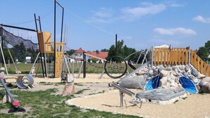 Une aire de jeux avec des structures d’escalade, des balançoires et un toboggan.