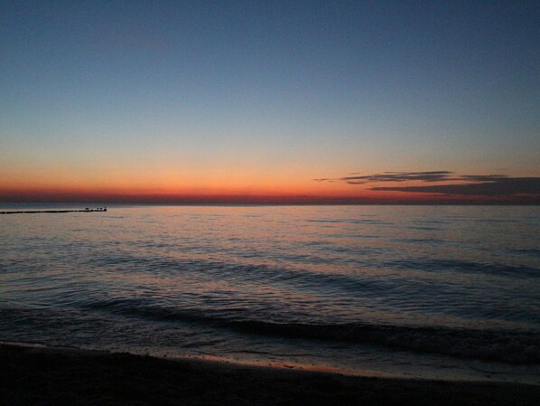 A calm sea at sunset with a pier extending into the water. - Ferienwohnung auf der Insel Poel Nahe Strand (Insel Poel)