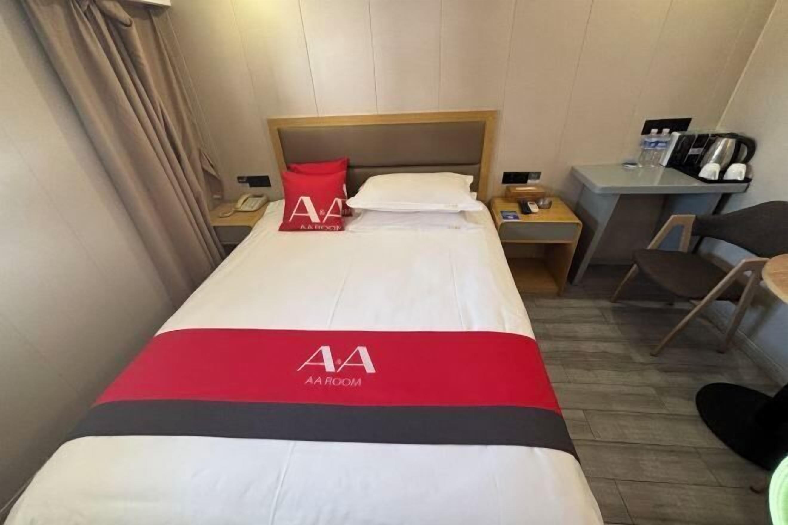 Une chambre d’hôtel avec un lit, un bureau et une chaise.