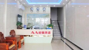 A hotel reception area with a reception desk, chairs, a staircase, and clocks displaying different time zones. - AA Hotel Chain (Quzhou International Financial Center Shuiting Branch) (Quzhou)