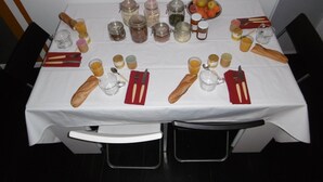 A dining table set with bread, utensils, and various condiments. - Le Clos D'ondres -spa Privé (Sarrant)