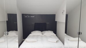 A modern hotel room with a large bed, a bedside table, and a mirror. - Le Clos D'ondres -spa Privé (Sarrant)