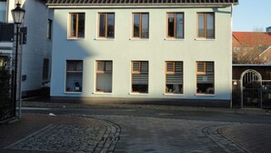 A two-story building with multiple windows and a gated entrance. - Time out Zu2! Modern Retreat (Cuxhaven)