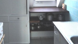 A compact kitchen with a small window, a microwave, and basic appliances. - Time out Zu2! Modern Retreat (Cuxhaven)