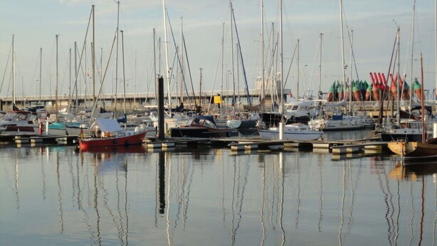 A marina with multiple boats docked, calm water, and a pier in the background. - Time out Zu2! Modern Retreat (Cuxhaven)