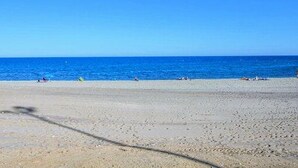 A beach with a clear sky and calm sea.