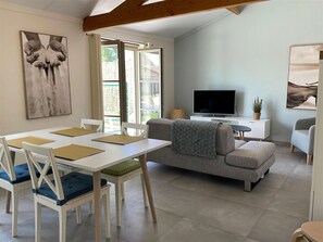 A modern living room with a dining area, a sofa, a TV, and artwork on the walls. - Holiday Home in Koksijde Near Sint-andre Beach (Koksijde)