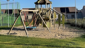 Une aire de jeux avec des balançoires et des structures d’escalade.