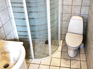 Bathroom features a toilet, shower, and sink with a clean, contemporary design.