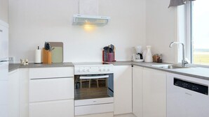 A compact kitchen with a built-in oven, a dishwasher, and a stove. - 6 Person Holiday Home in Harboore (Harboore)
