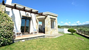 A stone building with a covered porch, a large window, and a door. - Villa in Alghero With Pool & Near Town (Alghero)