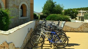 A stone building with a large arched window and a bicycle rack filled with bicycles. - Villa in Alghero With Pool & Near Town (Alghero)