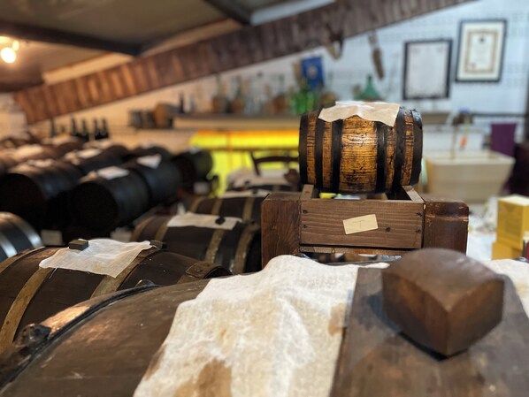 A storage area with wooden barrels and metal containers, likely for wine or spirits. - Cherry Tree Apartment (Ravarino)