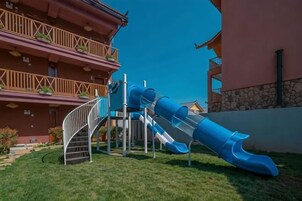 A multi-story building with a blue slide and stairs leading to the upper floors.