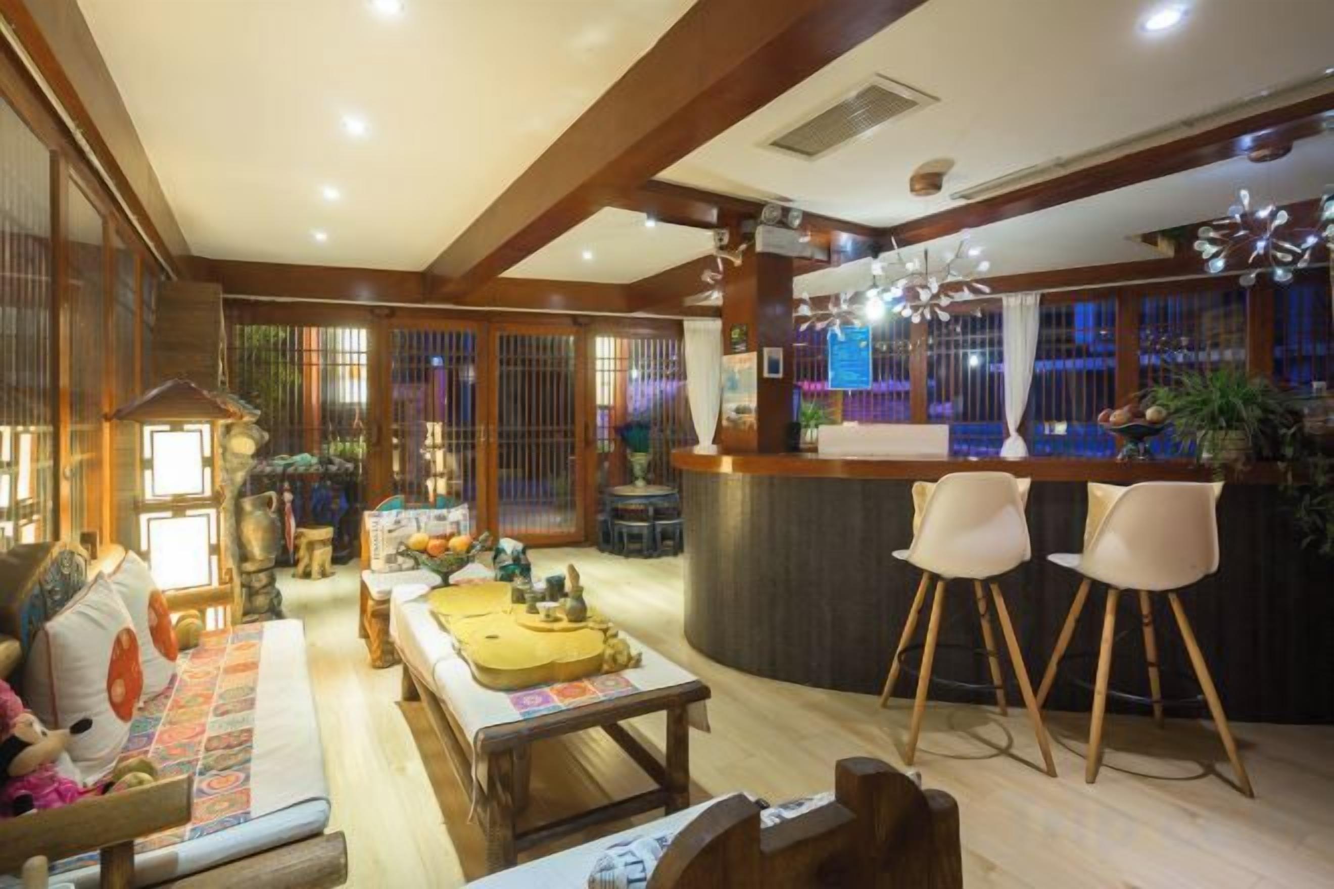 A spacious living area with a sofa, a coffee table, and a bar area with two chairs.
