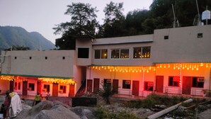 A building with multiple windows and a covered entrance area. - Hotel StudioZ Sahastradhara (Dehradun)