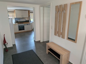 Un intérieur moderne comprenant un espace cuisine, un banc et un miroir.