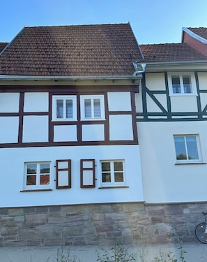 A traditional half-timbered house with a stone foundation, multiple windows, and a tiled roof. - Ferienhaus Fuldablick Das Ferienhaus Inmitten der Altstadt von Rotenburg /fulda (Rotenburg an der Fulda)