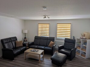 A living room with a sofa set, a coffee table, and a bookshelf.