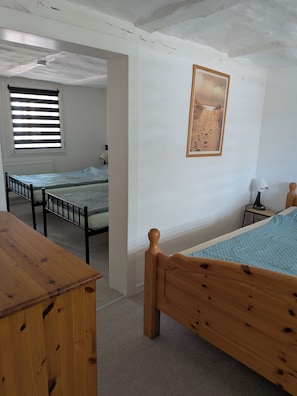 A room with two beds, a wooden table, a lamp, and a painting on the wall. - Ferienhaus Fuldablick Das Ferienhaus Inmitten der Altstadt von Rotenburg /fulda (Rotenburg an der Fulda)