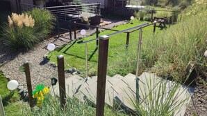 A modern house with a fenced backyard, a small deck, and a well-maintained lawn. - Chrissi's Baltic Sea Nest (Scharbeutz)