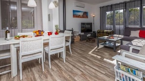 A spacious living area with a dining table, chairs, a sofa, a television, and a ceiling fan. - Apartment in Croatia Near the Adriatic Coast (Vinodol)