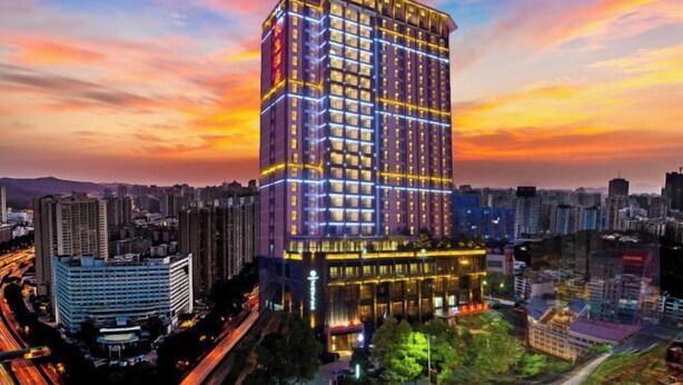 A high-rise hotel with a modern design, featuring a prominent corner location and a well-lit facade. - Minsheng Hotel (Yichang)