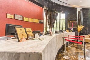 Een receptiebalie met ingelijste certificaten, een computer en een rode paal.