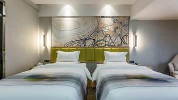 A hotel room with two beds, a large abstract painting on the wall, and a green accent wall.