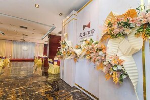 A hotel lobby with a marble floor, yellow chairs, and a floral decoration on the wall. - Minsheng Hotel (Yichang)