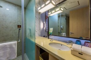 A modern bathroom with a glass shower enclosure, a beige sink, and a large mirror with integrated lighting. - Minsheng Hotel (Yichang)