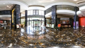 A spacious lobby with a polished marble floor, curved architecture, and a central entrance with glass doors. - Minsheng Hotel (Yichang)