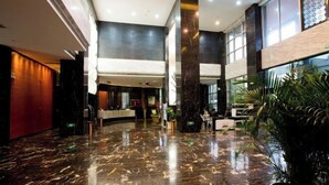 A spacious lobby with a polished marble floor, large pillars, and a reception desk. - Minsheng Hotel (Yichang)
