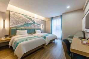 A hotel room with two beds, a desk, and a large wall art piece. - Minsheng Hotel (Yichang)