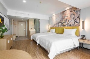 Ein modernes Hotelzimmer mit einem großen Bett, einem Nachttisch, einer Wandlampe und einem an der Wand befestigten Kunstwerk.