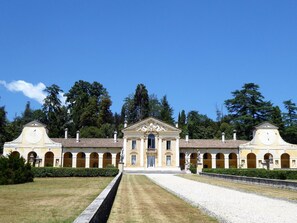 A classical building with a central entrance, arched windows, and statues. - Belvilla by OYO Ca' Landrini (Vo)
