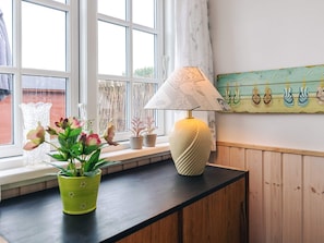 A room with a window, a lamp on a wooden counter, and a wall with a decorative item. - 3 Person Holiday Home in Karrebaeksminde (Karrebæksminde)