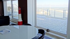 A modern hotel room with a large window offering a view of the sea and a bridge. - Seaside Serenity Apartment (Nieuwpoort)