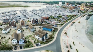 A coastal area with a marina filled with boats, a sandy beach, and a Ferris wheel in the distance. - Holiday Apartment 11deg East (Heiligenhafen)