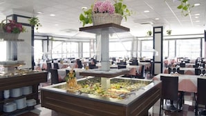 A buffet setup with multiple serving stations, a central display, and a checkered floor pattern. - Belvilla by OYO Apartment in Fuengirola (Fuengirola)