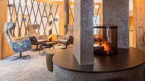 A modern lounge area with a stone fireplace, comfortable seating, and a decorative wall. - Modern Holiday Apartment With Balcony (Fuegen)